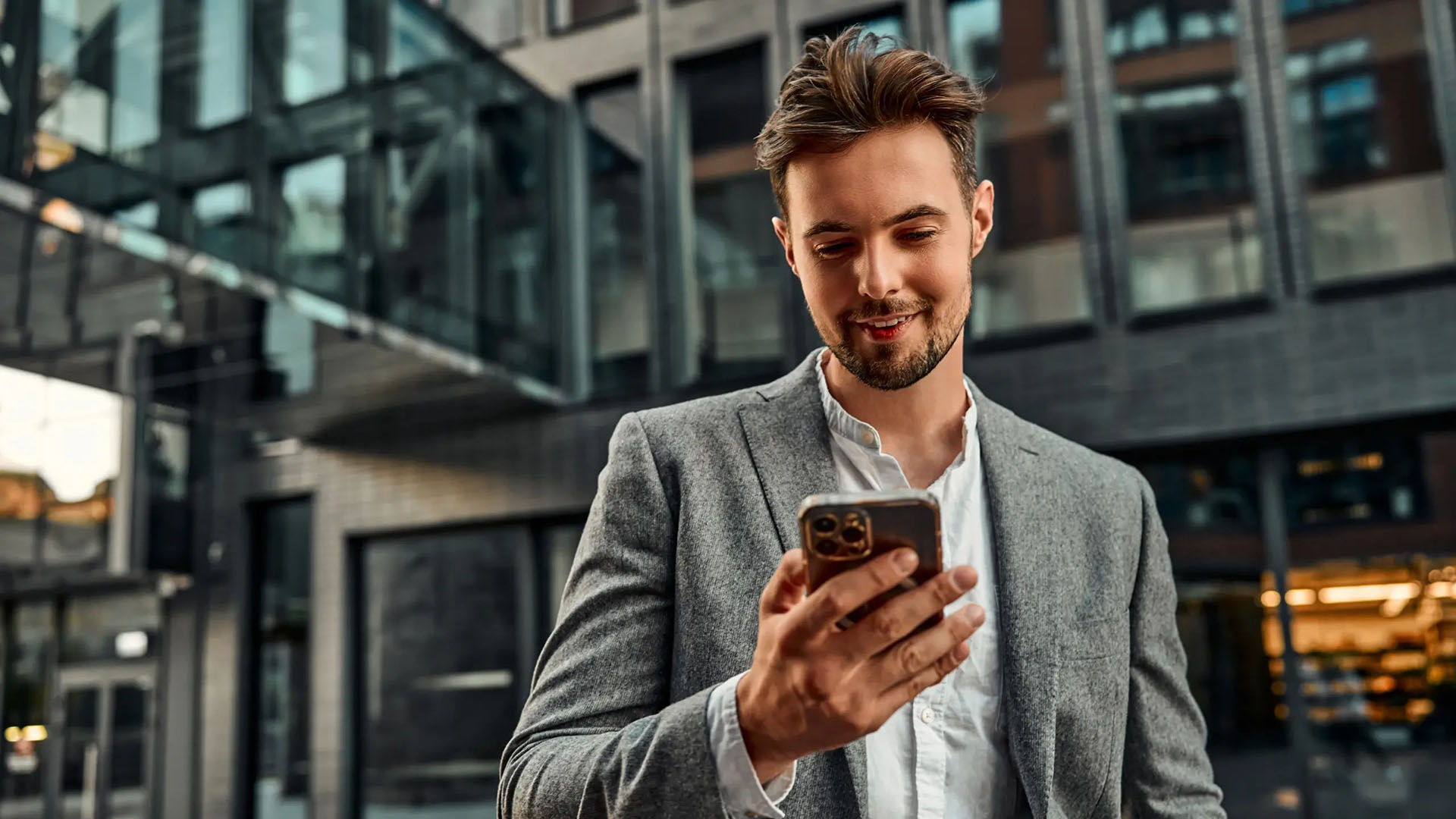 Blick auf ein Mietshaus mit großer Glasfassade und Balkons.