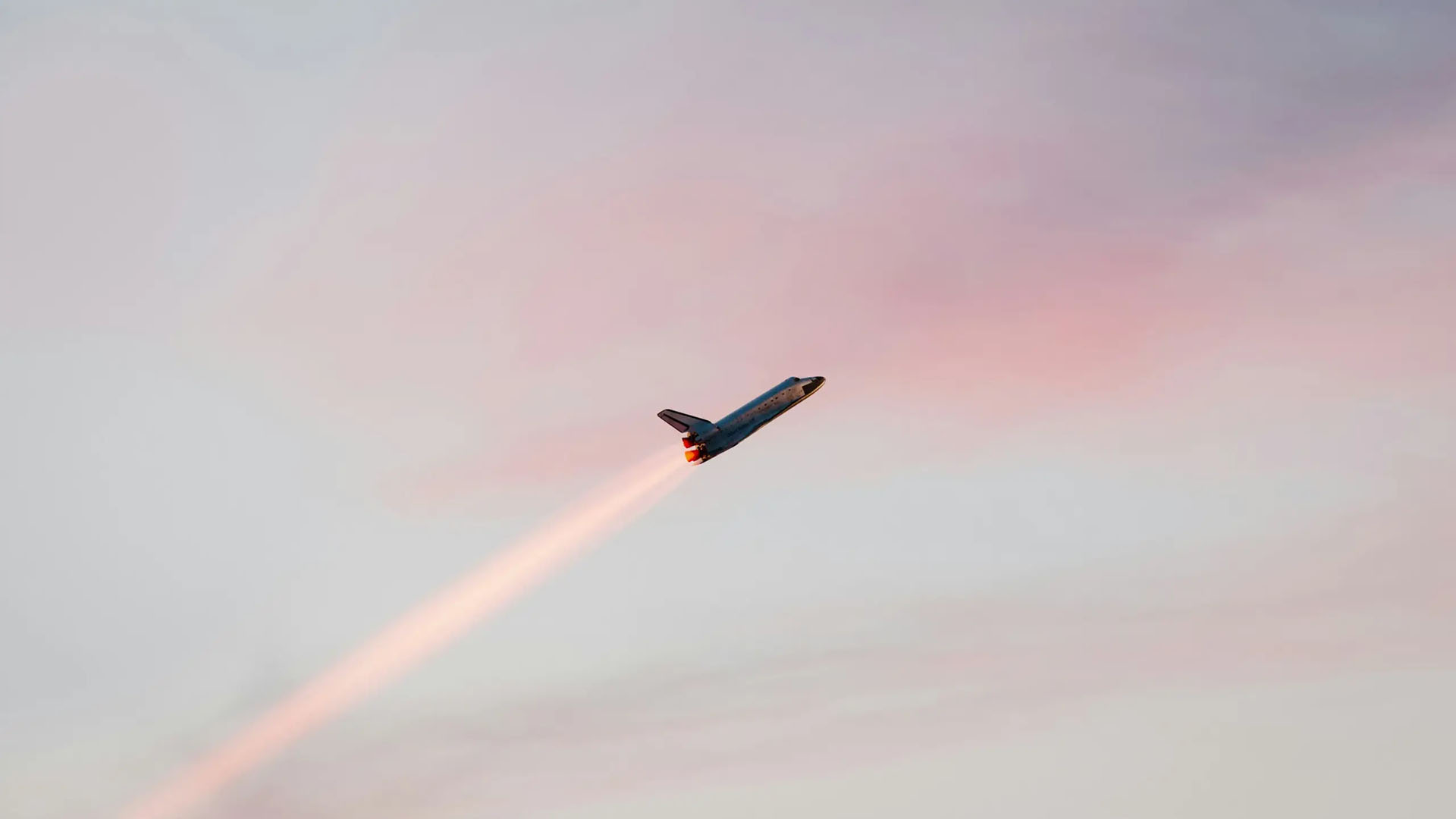 Blick auf ein Mietshaus mit großer Glasfassade und Balkons.